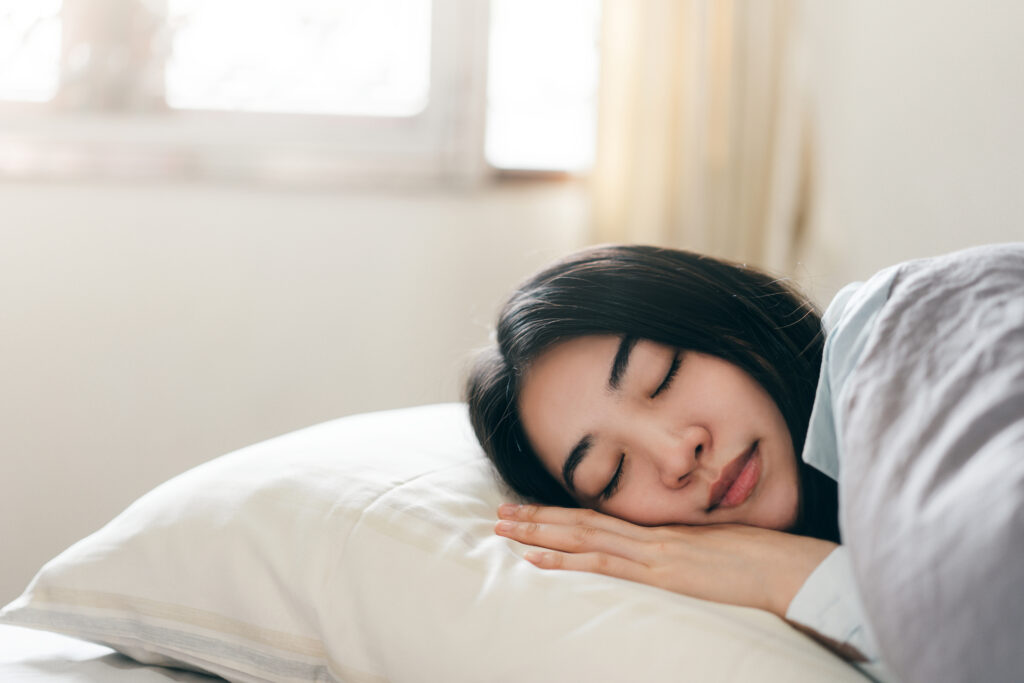 Young adult asian woman sleeping in a bedroom in the morning