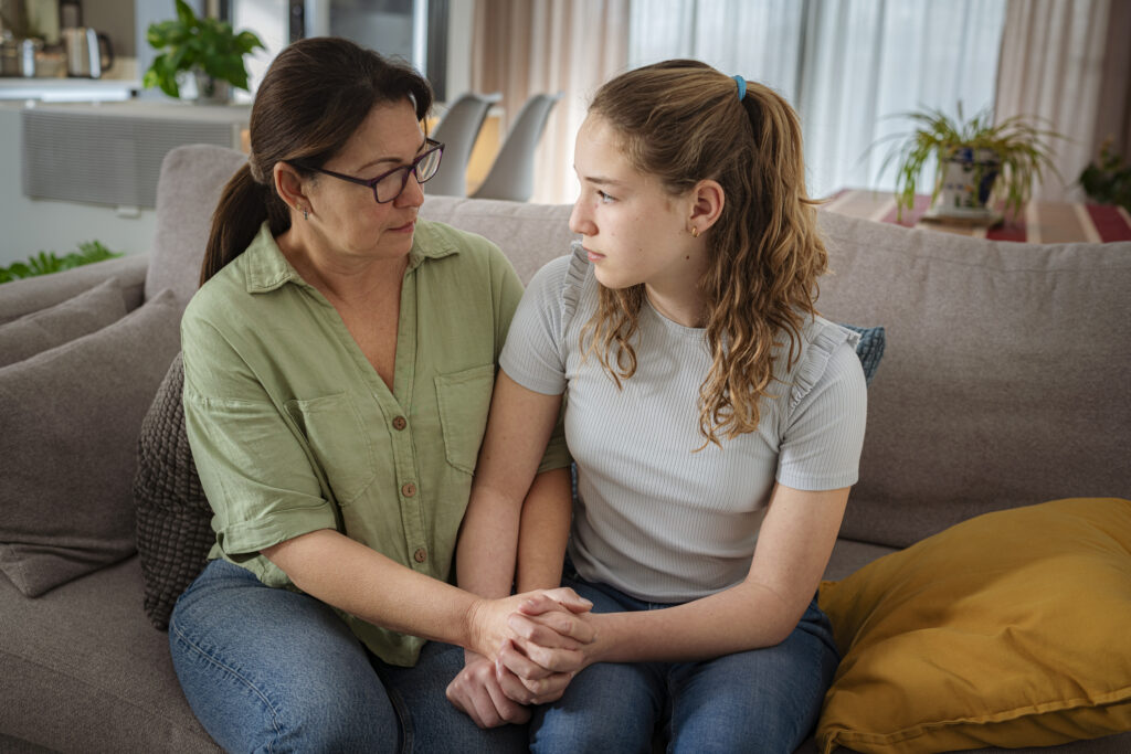 mother and daughter sitting on the couch talking